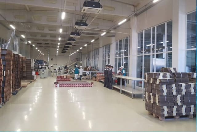 Сборочный участок: рабочие за столами, готовая продукция на паллетах